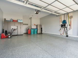 Custom Garage Cabinets and Storage in Chanhassen Modern Chanhassen garage featuring custom cabinets, slatwall storage, and overhead racks for organized, clutter-free space.