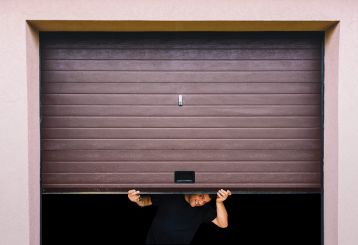 Technician performing garage door maintenance and safety inspection on a residential garage door in Chanhassen.