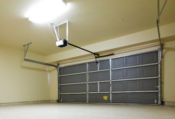 Garage door technician installing a new electric opener system in a residential garage in Chanhassen.