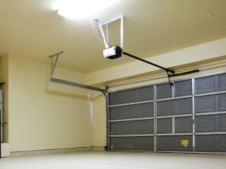 Technician Installing Garage Door Opener System Garage door technician installing a new electric opener system in a residential garage in Chanhassen.