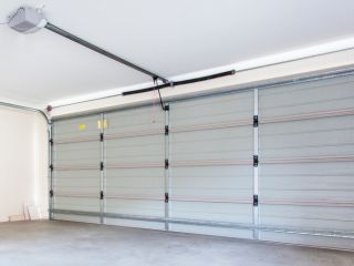 Technician Replacing Garage Door Spring Professional technician safely replacing a garage door spring in a residential garage in Chanhassen.
